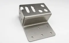 Bent sheet metal bracket with rectangular cutouts and mounting holes.